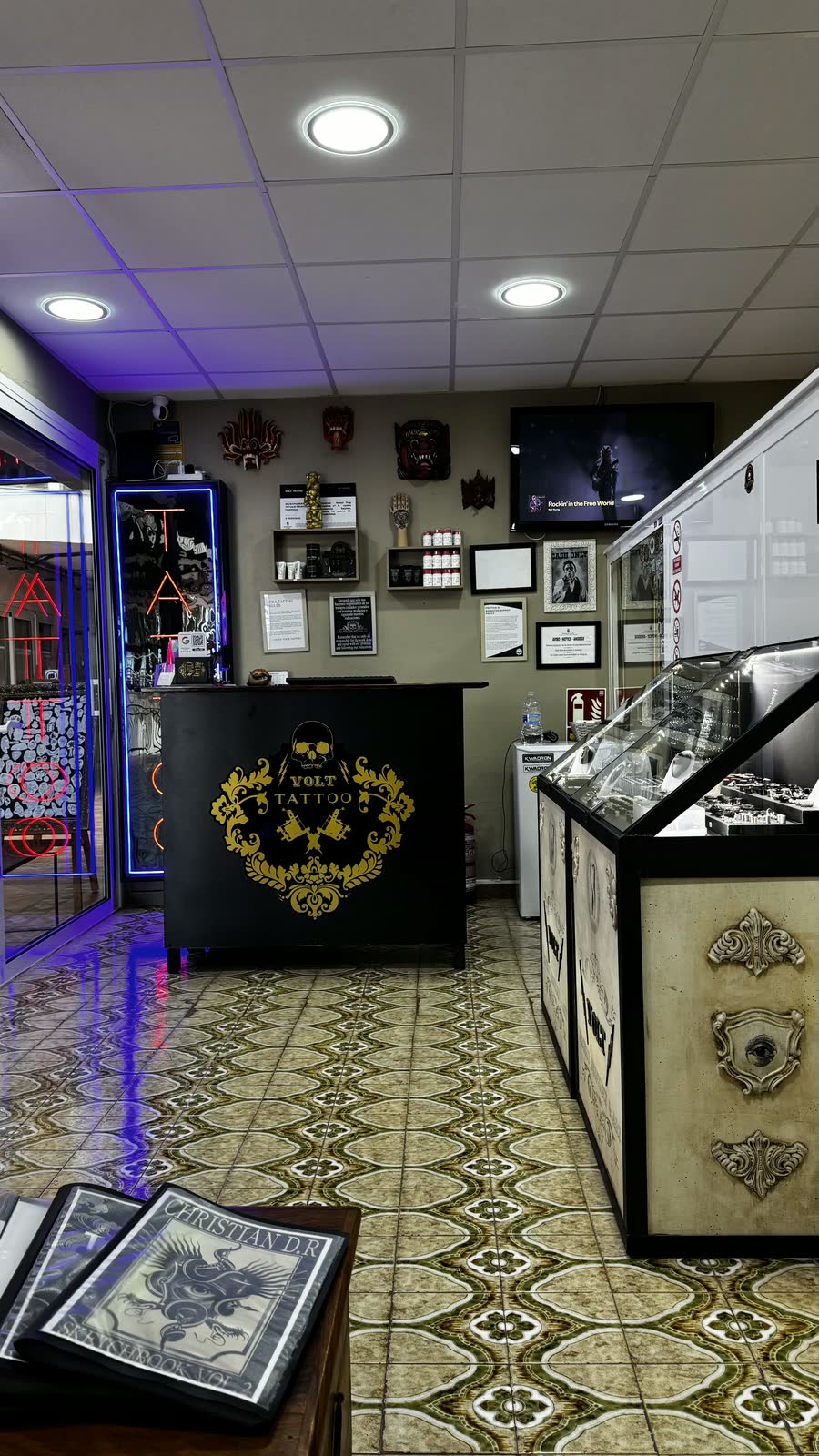 Recepción del estudio de tatuajes Volt Gallery Tattoo en Tenerife, con el logotipo dorado sobre el mostrador